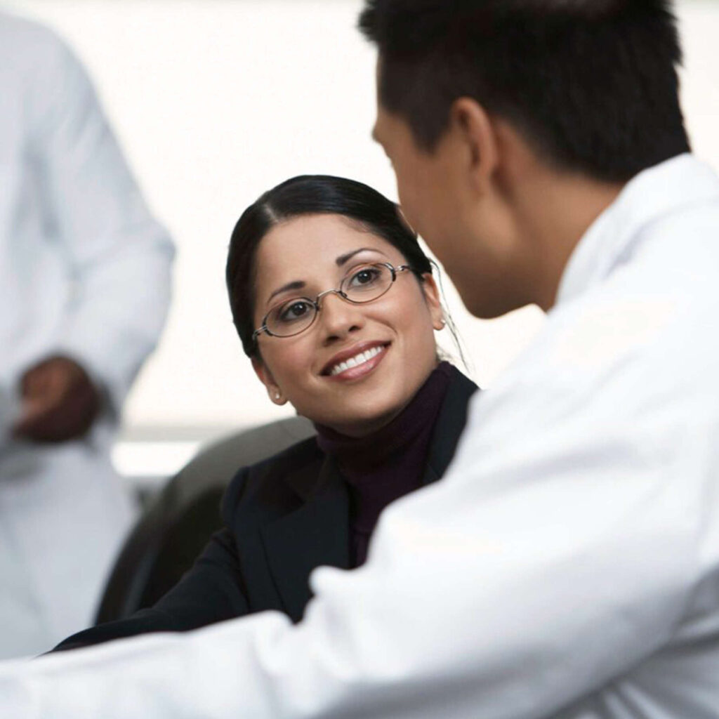 A friendly family doctor talking with a smiling patient